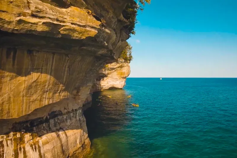 Kayakers next to the multicolored cliffs of Pictured Rocks National Lakeshore