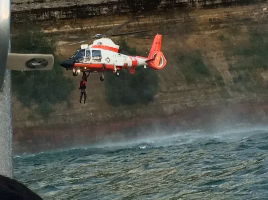 Coast Guard helicopter rescuing kayaker from the waters of Lake Superior along the Pictured Rocks NL cliffs